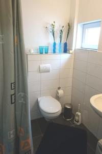 małą łazienkę z toaletą i umywalką w obiekcie Ferienhaus Toni im Stadtkern von Bremervörde w mieście Bremervörde