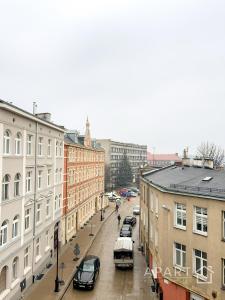 a city street with parked cars and buildings at Gdansk Central Apartment in Gdańsk