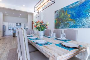 uma sala de jantar com uma mesa e um quadro na parede em Palacio Blanco Luxury Villa 1 em La Ventana