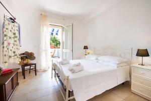 Habitación blanca con cama y ventana en Casa Acquamarina - comfort e relax a pochi passi dalle spiagge del Salento, en Lido Marini