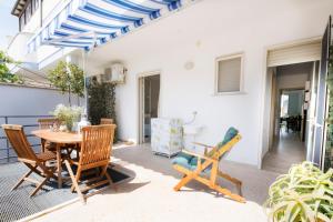 un patio con mesa de madera y sillas en Casa Acquamarina - comfort e relax a pochi passi dalle spiagge del Salento, en Lido Marini