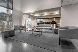 Sala de estar con sofás y mesa de centro en City Express by Marriott Celaya Galerias, en Celaya