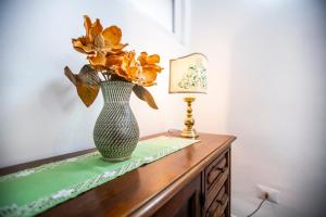 un vaso con fiori su un tavolo accanto a una lampada di Casa di Bruno a Pellio Superiore
