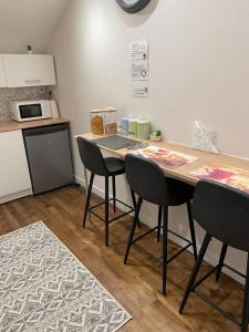 a kitchen with a counter with chairs and a table at Sunflowers in Le Dorat