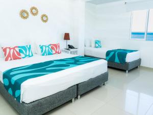 two beds in a room with white walls at Hotel Caribbean Coral in San Andrés