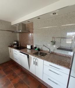 - une cuisine avec des placards blancs et un évier dans l'établissement Segunda Ibáñez, à Áreas