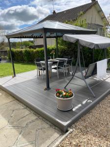 a wooden deck with a table and an umbrella at Sunflowers in Le Dorat
