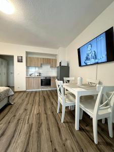 a living room with a table and chairs and a kitchen at E&K Apartment I in Düsseldorf