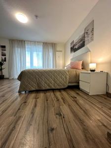 1 dormitorio con 1 cama y suelo de madera en E&K Apartment I en Düsseldorf