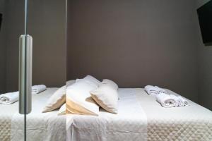 twee foto's van een bed met witte lakens en kussens bij Casetta Robinie in Como