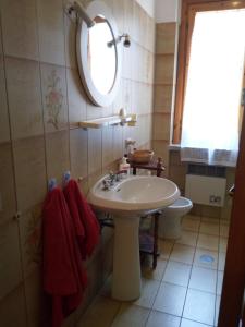 y baño con lavabo, espejo y aseo. en Villetta Pescespada, en Grosseto