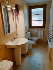 La salle de bains est pourvue d'un lavabo, de 2 toilettes et d'une fenêtre. dans l'établissement Apartamento Baztan - Arraioz, à Arráyoz
