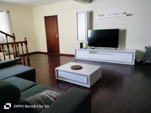 ein Wohnzimmer mit einem Flachbild-TV und einem Sofa in der Unterkunft casa sousa in Campanário