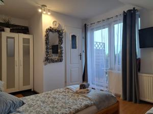 a bedroom with a bed and a mirror and a window at Willa Krakowia in Krzeszowice
