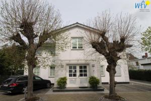 una casa bianca con due alberi davanti di Ferienhaus Rademacher Ferienwohnung 2 a Binz