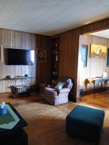 a living room with a couch and a flat screen tv at Hemlock House in Ironwood