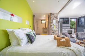 ein Schlafzimmer mit einem großen weißen Bett mit grünen Wänden in der Unterkunft Chalet étoilé BAYALOCATION in Le Lamentin