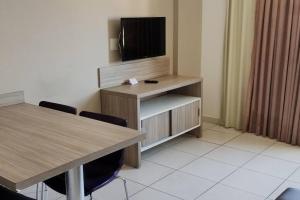 una habitación con 2 mesas y TV en una habitación en Apartamento Privê Riviera 10, en Caldas Novas