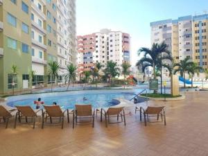 una piscina con sillas y un grupo de edificios en Apartamento Privê Riviera 10, en Caldas Novas