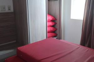 een stapel rode kussens in een kamer bij Apartamento Privê Riviera 10 in Caldas Novas