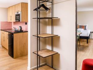 a kitchen and a living room with shelves at Nq2 Collections in Bournemouth