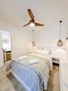 a white bedroom with a bed and a ceiling fan at Mountain Bliss Guesthouse 2 next to Sougia in Agrilés