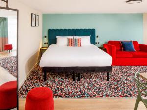 - une chambre avec un lit et un canapé rouge dans l'établissement Nq2 Collections, à Bournemouth