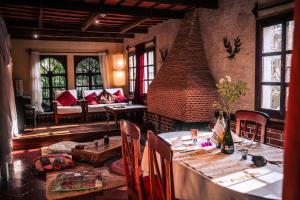 a dining room with a table and a brick fireplace at Baraka Antigua in Antigua Guatemala