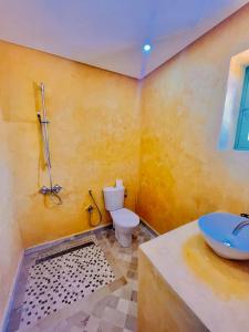 a bathroom with a white toilet and a sink at DIAR HAROUN in Djerba
