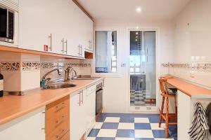a kitchen with white cabinets and a sink at Appartement avec vue sur mer Calahonda (Mijas) in Sitio de Calahonda