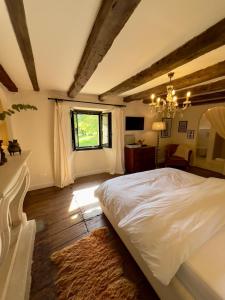 ein Schlafzimmer mit einem weißen Bett und einem Fenster in der Unterkunft Maison G.H. in Champniers-et-Reilhac