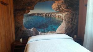 1 dormitorio con una pintura de una pared de roca en La cabaña, en Cedeira