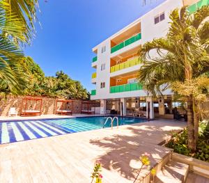 an image of a building with a swimming pool and palm trees at Hotel Caribbean Coral in San Andrés