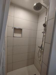 a shower in a bathroom with white tiles at Fargeot in Saint-Jean-de-Luz