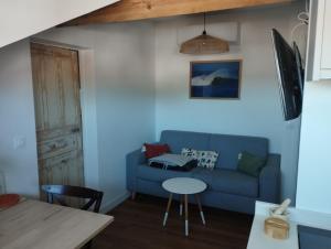 a living room with a blue couch and a table at Fargeot in Saint-Jean-de-Luz