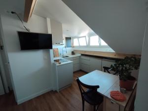 a kitchen with a white refrigerator and a table at Fargeot in Saint-Jean-de-Luz +2 photos