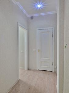 ein leeres Zimmer mit einer weißen Tür und einem Fenster in der Unterkunft Апартаменты в центре города in Aqtau