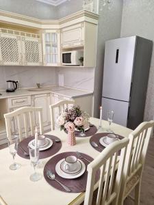 eine Küche mit einem Tisch mit Tellern und Kerzen darauf in der Unterkunft Апартаменты в центре города in Aqtau