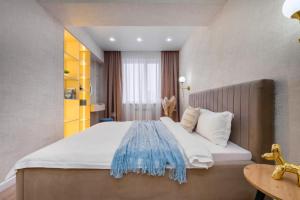 1 dormitorio con 1 cama grande y cabecero de madera en Стильная квартира в центре города, en Almaty