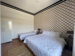 um quarto com 2 camas e uma parede estampada em Banana Surf House em Tamri