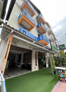 a building with blue and orange stairs and a green yard at Retro guesthouse in Pattaya South