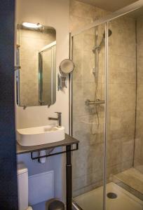 uma casa de banho com um lavatório e um chuveiro em Charmant studio em Saint-Aubin-de-Médoc