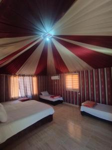 a bedroom with two beds and a ceiling at Waid Rum Jordan Jordan in Wadi Rum