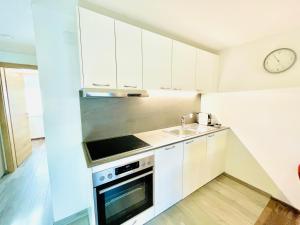 a kitchen with white cabinets and a sink at Villa Maria Theresia - contactless Self-Check-IN in Bad Goisern