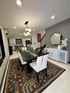 a dining room with a black table and white chairs at Saugerties Modern Charm with Creekside access and views in Saugerties