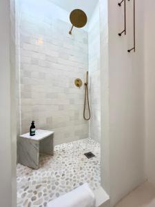 ein weißes Bad mit einer Dusche und einem Waschbecken in der Unterkunft Maison G.H. in Champniers-et-Reilhac