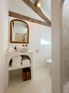ein weißes Badezimmer mit einem Waschbecken und einem Spiegel in der Unterkunft Maison G.H. in Champniers-et-Reilhac