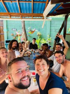 een groep mensen die rond een tafel zitten bij taganga macabi hostel in Santa Marta