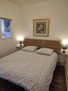 a bedroom with a bed and two pictures on the wall at T1 lumineux et climatisé in Chagny