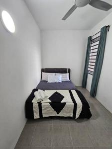 una camera da letto con un letto con un piumone bianco e nero di E! Best Apartment a Padang Serai Altre 9 foto